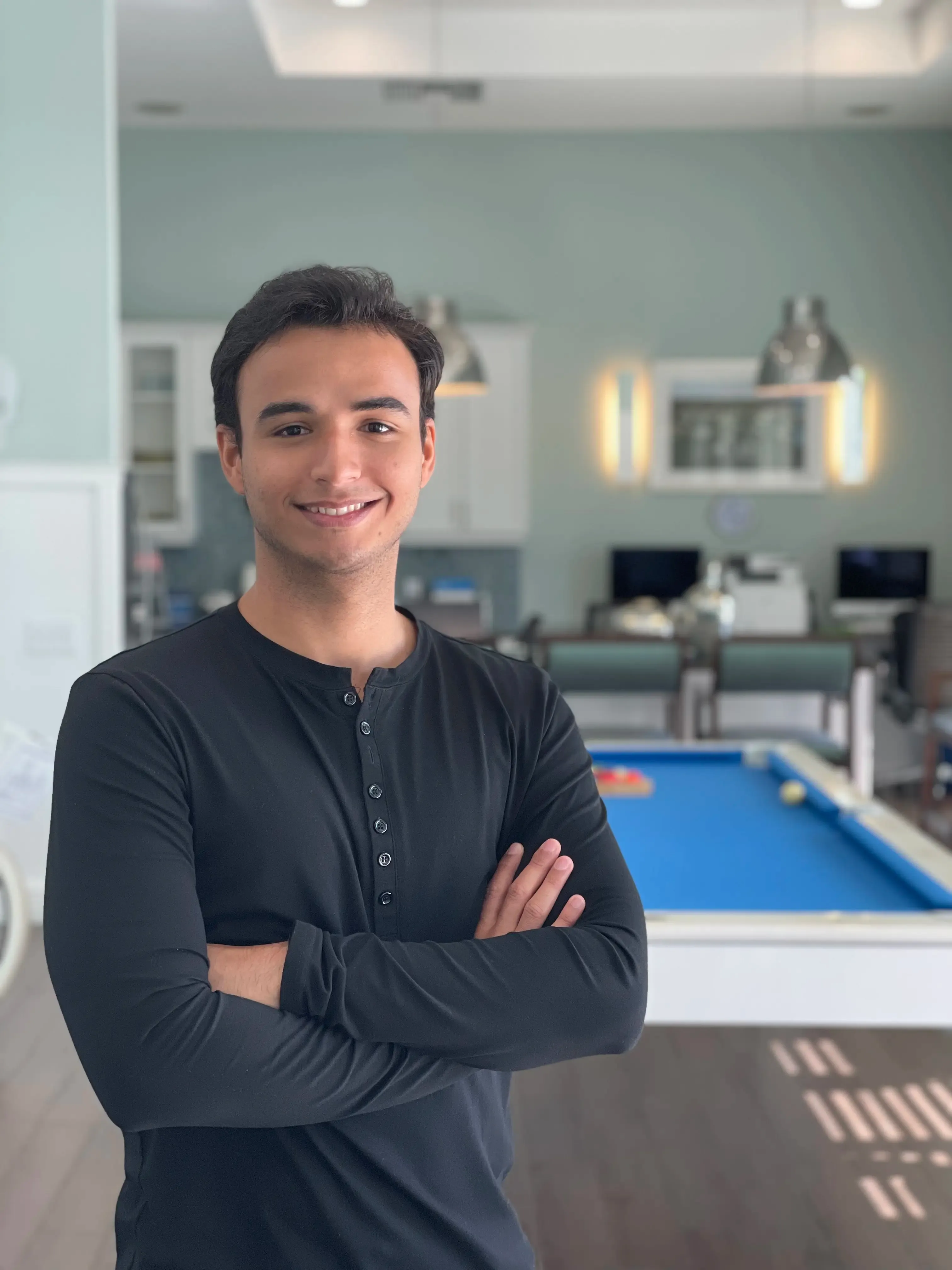 Daniel Moya smiling in a blue shirt and tint pants